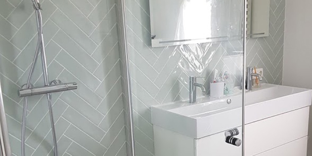 Douche met visgraat betegelde wand