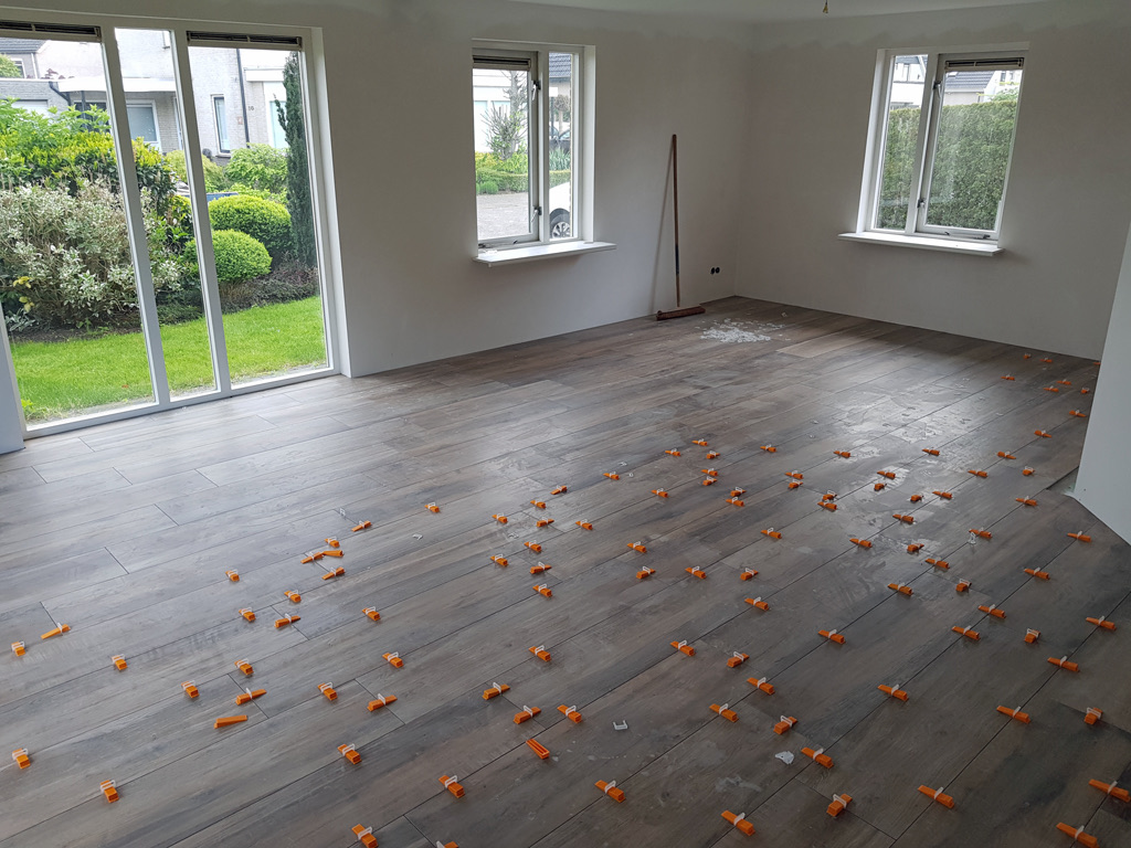 Keramische tegels gelegd met oranje levelling-clips
