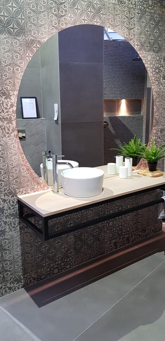 Trendbadkamer met ronde spiegel en donker behang